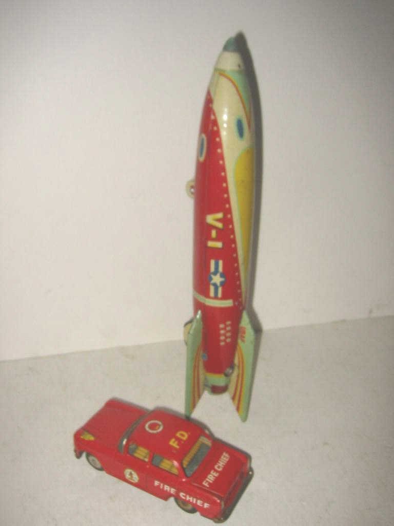 Lot of Two Vintage 1950's Toys: 1950's lithograph tin rocket ship made in Japan and a fire chiefs car, no name, tin lithograph. Both in good condition.