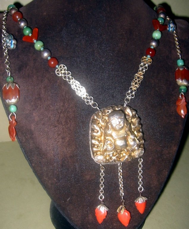 Silver Chinese Necklace: Chinese silver necklace fitted with turquoise, carnelian, silver and coral bead work with a large silver Buddha pendant. Early to mid 20th century in very good condition.