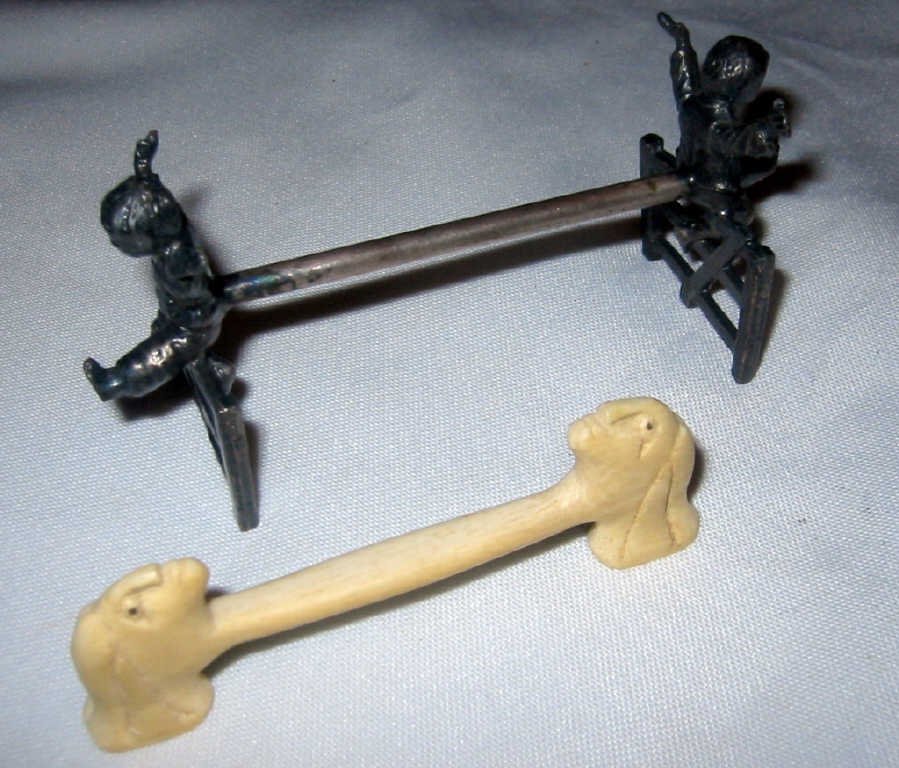 Two Antique Figural Knife Wrests: Two figural antique knife wrests. One is of little boys jumping a fence made of silver plate the other is made of bone and is an Indian head motif. In good condition.