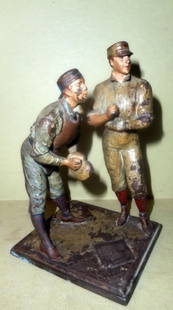 19th Century Basebell Figurine (As Is): White metal baseball figurine. It is cold painted and in as is condition. The baseball player is missing his bat and one hand. The player has also been re-attached. C.a. 1890. Measures 6" tall.