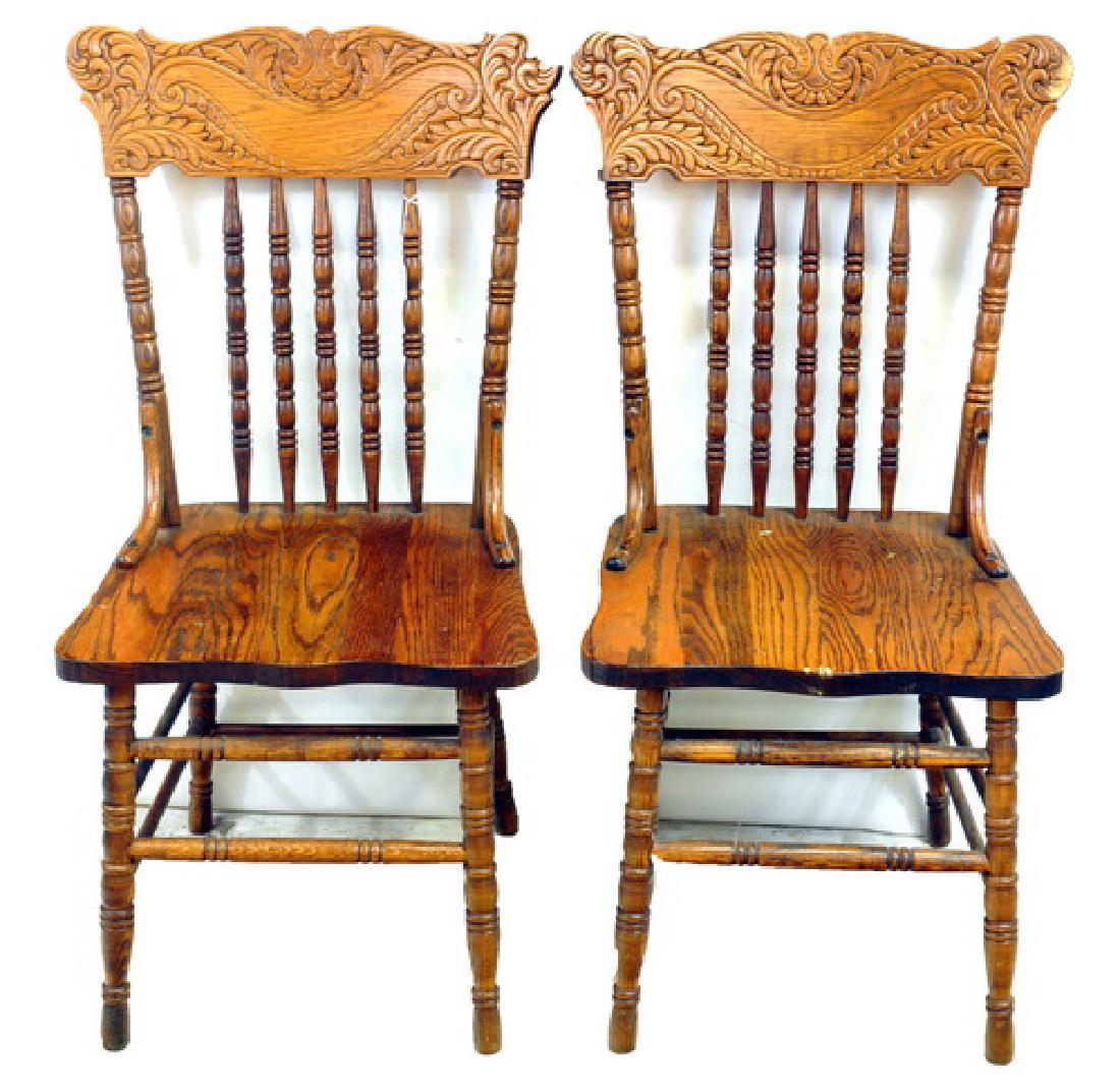Four antique oak pressed back side chairs: intricately carved scrolls and leaves, 38 x 20 x 16. Two chairs have significant wear and scratches.