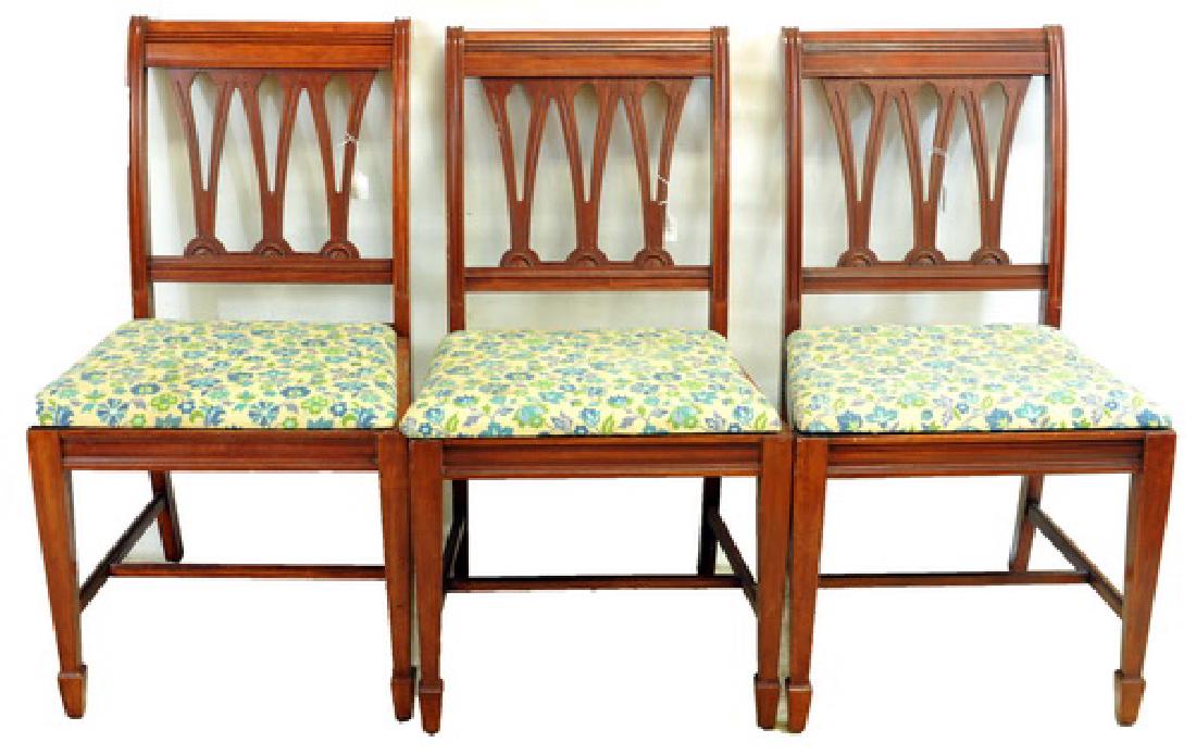 Six antique mahogany side chairs: one armchair with floral upholstered seating, one is missing.