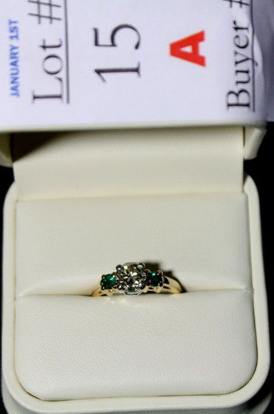 14Kt. gold and platinum ring with 1 ct. diamond ce: 14Kt. gold and platinum ring with 1 ct. diamond center stone with 2 round emeralds, Diamond is K/L in color and VS2 in clarity, replacement cost is $7686.00