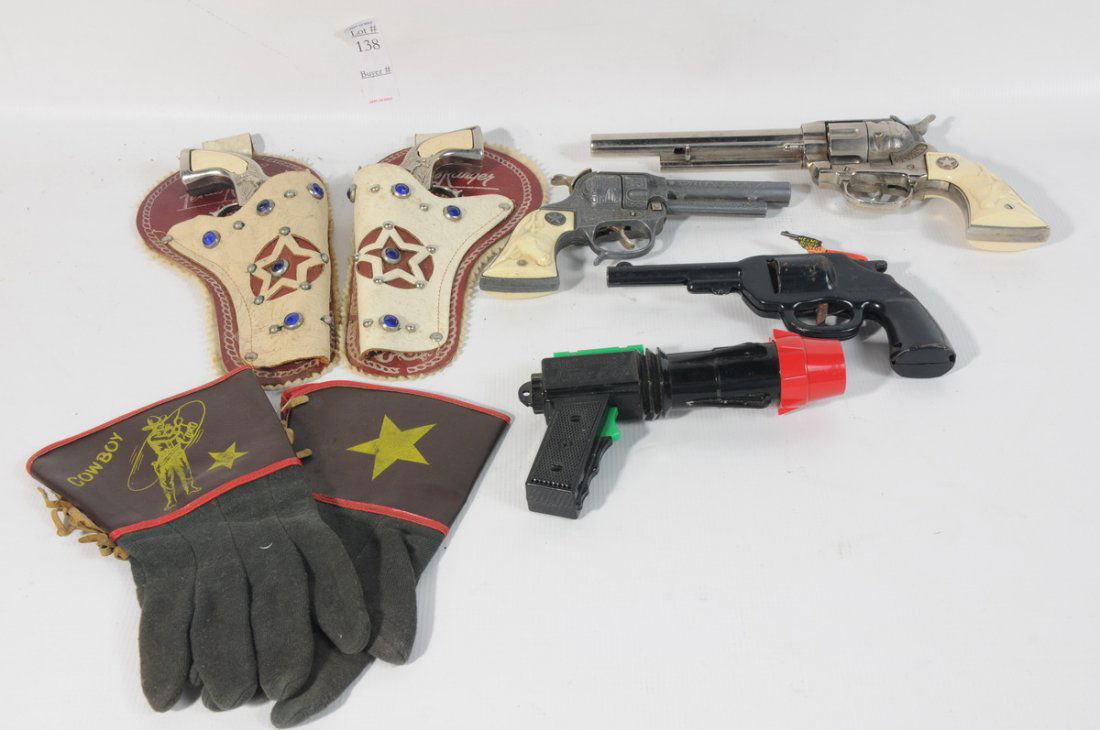 Collection of Toy Guns including a matching set of: Collection of Toy Guns including a matching set of Texas Ranger cap pistols in jeweled holsters with leather cowboy gloves, a cowboy revolver, a Texan Jr. Revolver, A Wyandotte Buddy Pistol, and a Buc