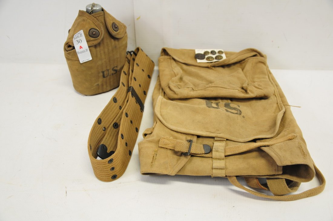 Lot of WWI Military Issue Field Gear: To include: a 1918 web belt made by Russell, 5 WWI buttons and a collar disk, a 1918 field pack, and a Jan. 1918 canteen in canvas case.