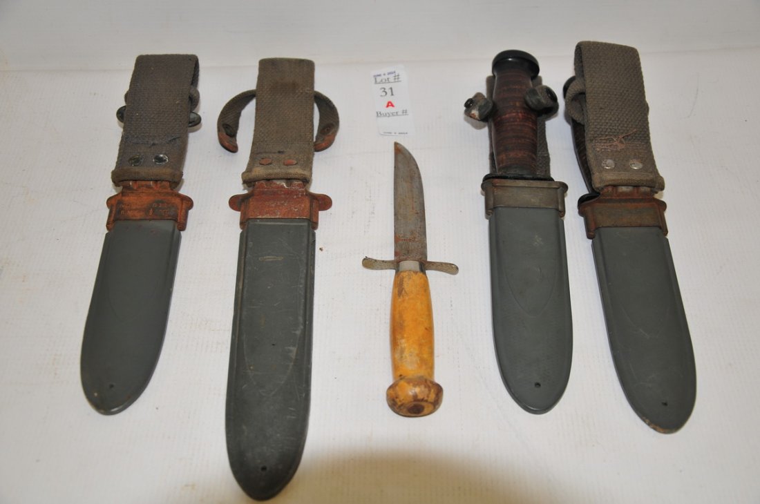 Two MK 1 USN fight Knifes with scabbards: This is US fighting knifes. Manufactured by Camillus. The handles are made of a series of compressed leather rings. At certain intervals the color of the rings change from dark brown to yellow or red.