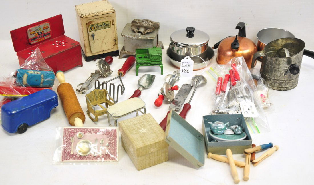 Vintage Doll House Furniture and Kitchen Sets: Lot includes a child's Revere Ware set, a cast metal Pretty Maid Stove, a Star cast iron wood stove, Pretty Maid fridge, sets of red wood handled utensils, two porcelain tea sets, cast metal furniture