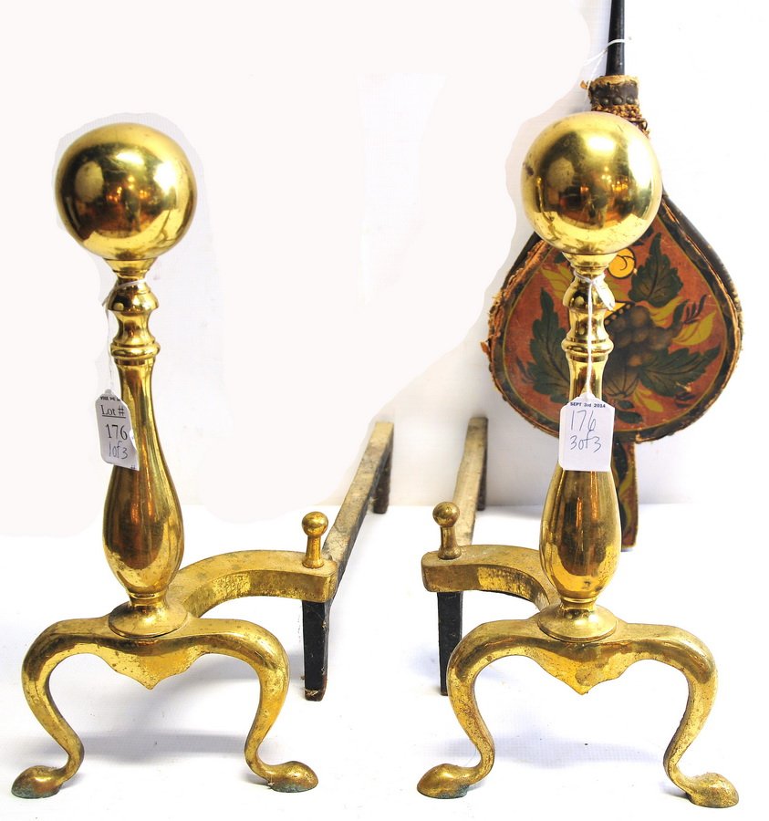 Pair of andirons in gold color with an old bellows: Andirons 17 x 16 and bellows is decorative with cornucopia motif, made of leather and wood, condition fair, 20" L x 8" W.