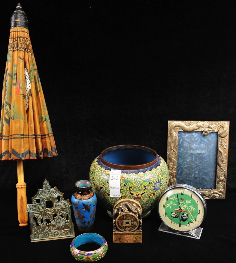 Lot of Mixed Asian Smalls: Includes an enamel planter measuring approx. 7" X 8," a small enamel vase, an enamel bangle, a Chinese alarm clock, silver plated dragon motif frame, a Chinese zodiac stamp, a brass bookend, and a par