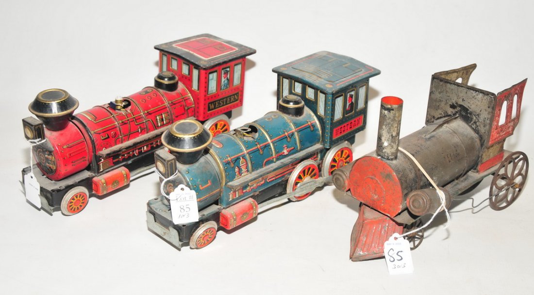 3 Vintage tin toy trains: Two of the train engines are made in Japan from the mid 60s. The third toy train is older and is spring operated.