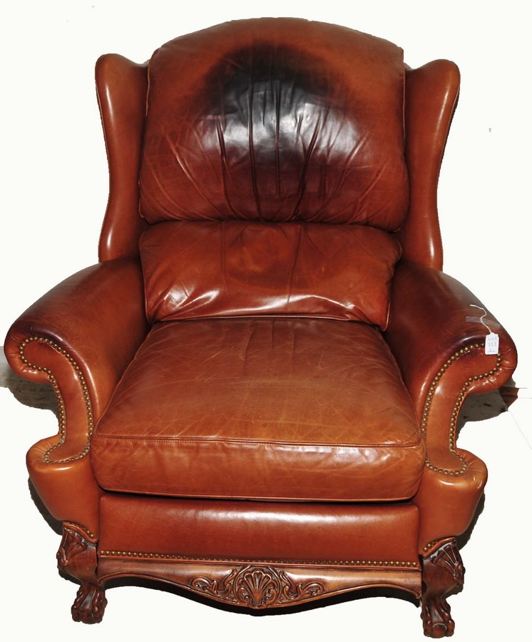 Antique Leather Wingback recliner: With Intricately carved base, ball and claw feet