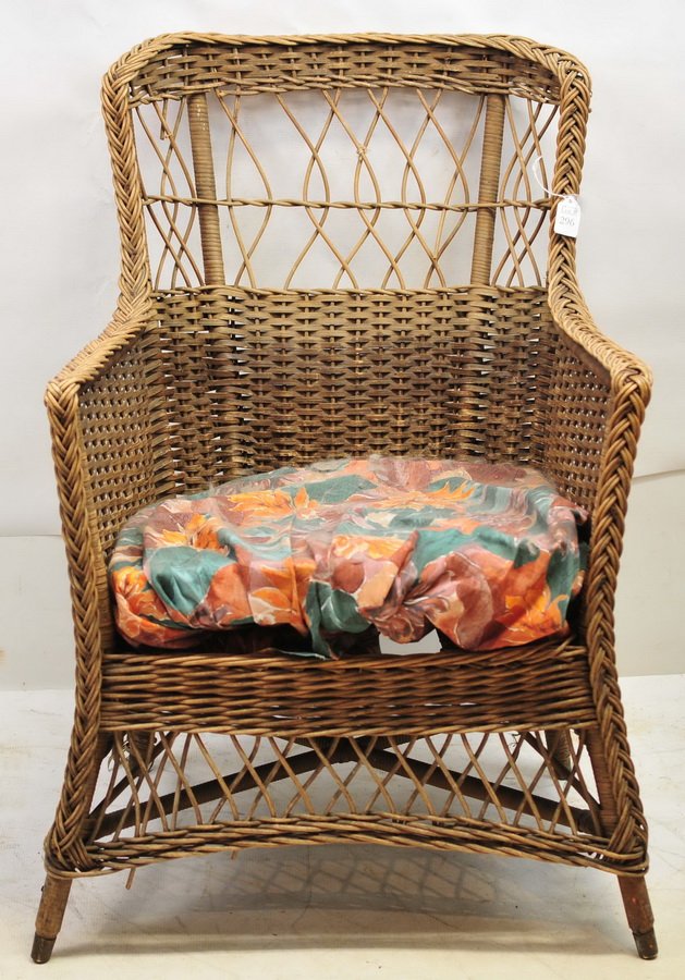 Antique natural wicker arm chair: with spring bottom seat, 34" H x 24" W x 21" D.