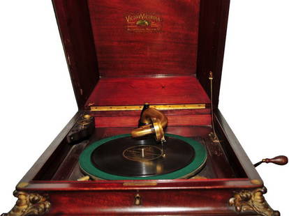 Victor Victrola Talking Machine: In Working Condition with numerous records. Mahogany Cabinet, brass adorned, measures 50x21x21. In 1908, Victor introduced a super-deluxe VTLA model, advertised as "Victrola the Twentieth" (although t