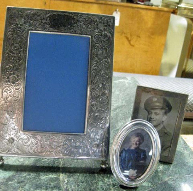 3 Easel Back Picture Frames: 1 sterling silver with incised floral decor, 10 x 7 inches (missing glass), 1 Tiffany and Co. Sterling silver frame, 5 x 3 1/2 inches, and 1 silvered metal oval frame, 4 1/2 x 3 inches