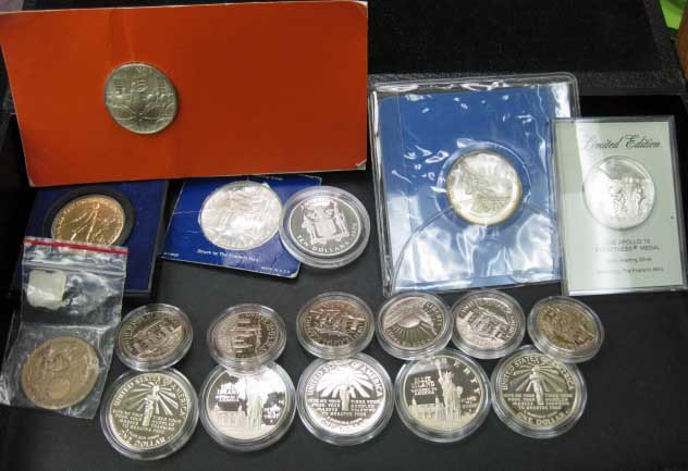 Assorted Commerative Coins: some being silver, Apollo 15 and Man on the Moon commemorative silver coins, 5 Ellis Island dollars and 6 half dollars, 2 Jamaican $10 silver coins, Continental Congress silver coin, Old Faithful and 