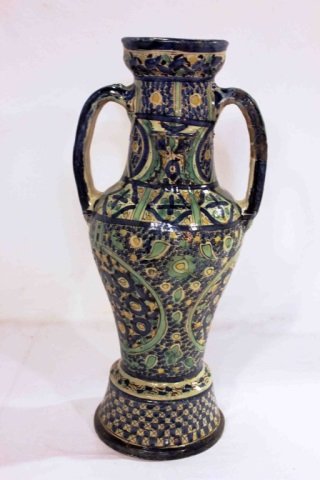 Middle Eastern Pottery 2 Handle Urn: Height 21.5 inches Width 10 inches Diameter of opening 5 inches. Hand painted geometric design motif two hand urn.