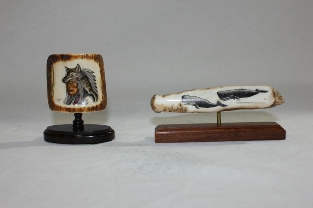 Two Scrimshaw Articles: Height of tallest 3 inches. Two carved bone scrimshaw articles. Eskimo / inuit / Alaskan in origin. Both mounted on stands. One with whales and one with portrait of a man.