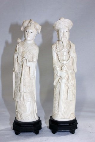 Pair of Ivory Figures - Emperor and Empress: Height 10 inches. Carved ivory Chinese or Japanese nobleman and noblewoman. Each resting on a small wood base. Cloaked in robes.