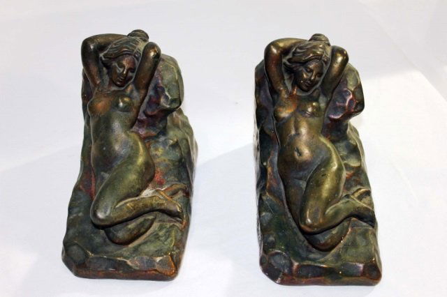 Pair of Art Nouveau Metal Bookends: Height 5.5 inches Length 8 inches. In the form of reclining nude women on rocks. Well executed detail. Ideal for office, library, or study.