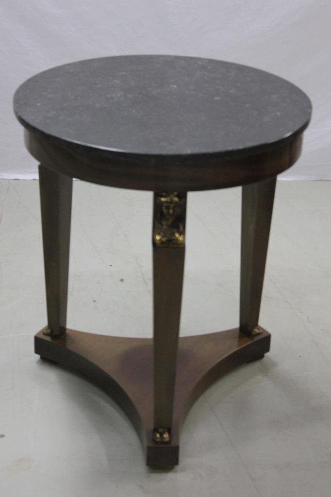 Empire Style Egyptian Revival Marble Top End Table: Each column leg having a gilt bronze bust as capital. Height 27 inches. Diameter of marble top 23 inches. Estate of Warren Dieter Zander.