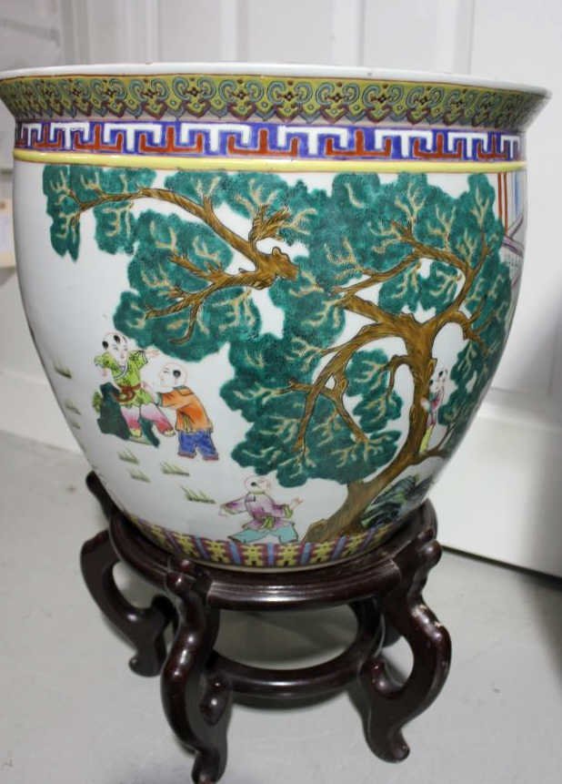 Chinese Porcelain Planter Pot on Stand: Hand painted on a carved wood base. Height w. stand 23 inches. Diameter 18 inches. Property of a Greenwich CT Estate.