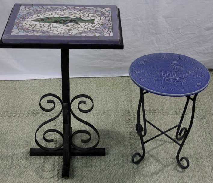 Two Wrought Iron & Tile Top Patio Tables: Property of a Bedford NY Estate. One majolica garden scene. One Mosaic fish scene. Larger of the two: Height 36 inches. Width 21 inches. Depth 16.5 inches.