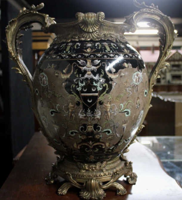 Gilt Bronze & Hand Painted Porcelain Faience Urn: Height 18 inches. Width 16 inches. Property of a Bedford NY Home. Marked in the bottom "Castelian" with foil label "made in China".