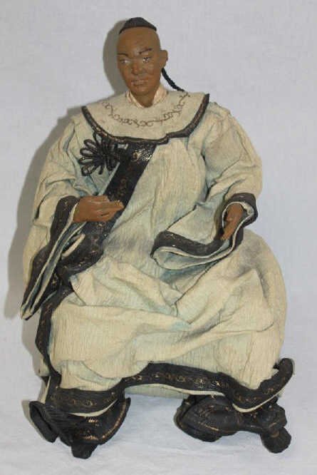 Antique Chinese Doll of Seated Robed Man: Head and hands made of sculpted and molded clay Robes made of paper fabric Height 15 Inches Width 10 Inches Depth 9 Inches