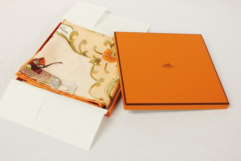 Hermes "Cheval Turc." Silk Scarf: Orange with horse and figure in center.