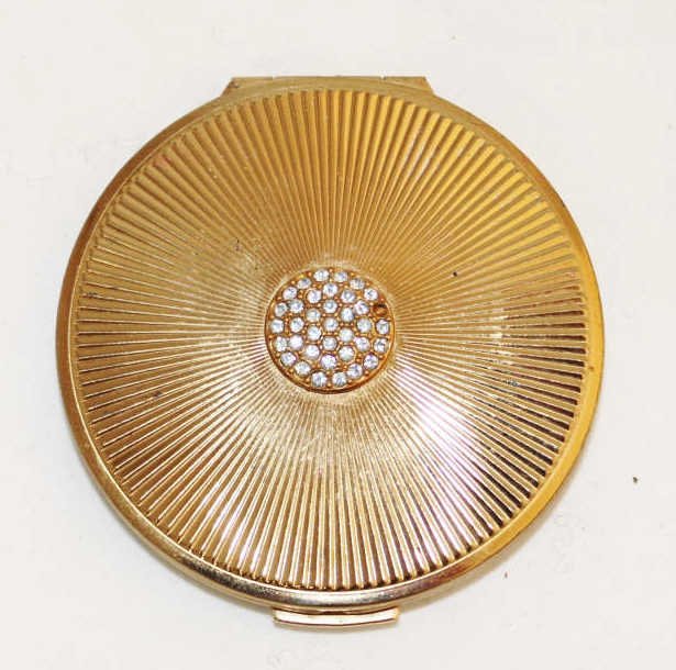 Stratton English Compact Mirror: With compartment for powder. Marked Stratton, Made in England. Top with a small cluster of stones, some missing .Diameter 3 inches