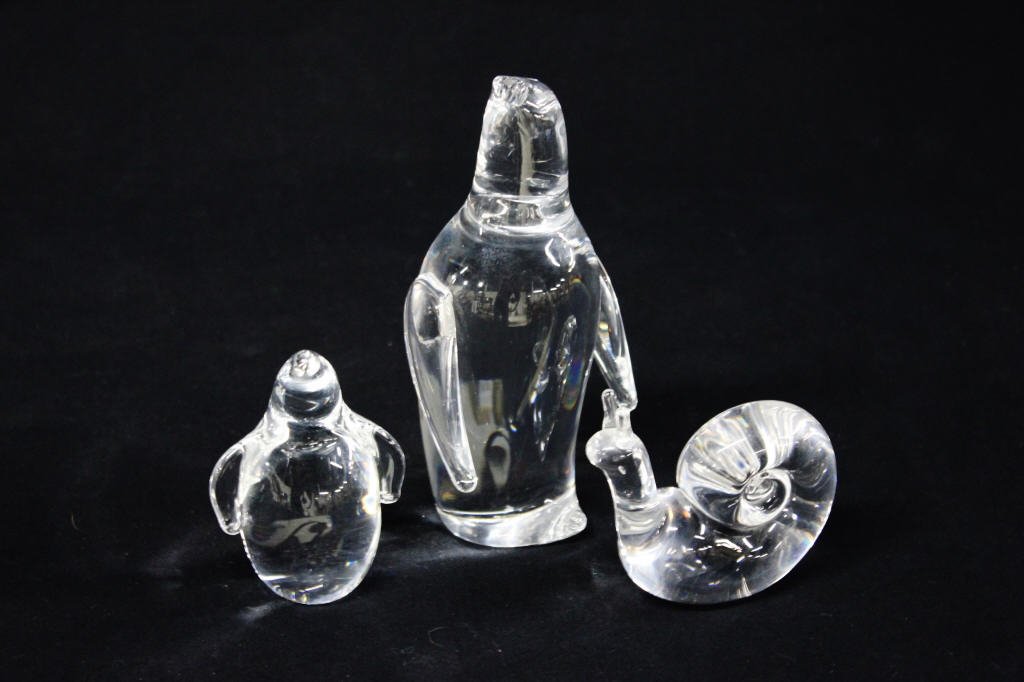 Group of Three Steuben Glass Figurines: A large penguin, a small penguin, and a snail. All signed Stuben on bottom. Height of tallest penguin 6.5 Inches