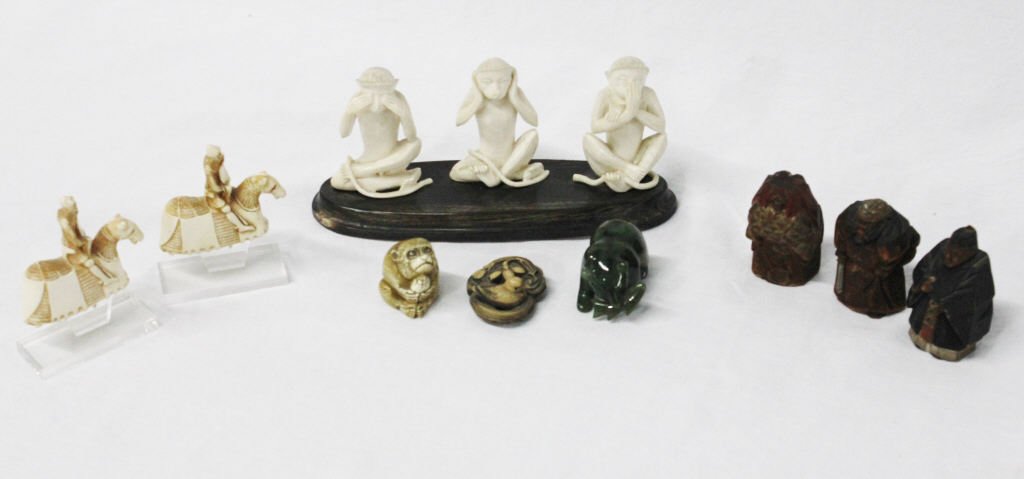 Group of Assorted Carved Decorative Items: Three carved ivory monkeys on a stand, two carved ivory knights on horses with stands, three carved wood figures, four carved wood musicians, an ivory monkey, a carved walnut bird in pond, and a jade 