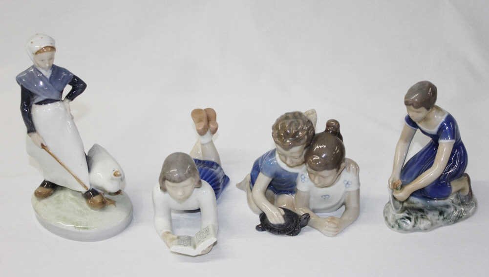 Four Royal Copenhagen Figurines: 528- woman with duck, 2356- woman planting a flower, 2304- girl reading a book, and 4A- young boy and girl playing with turtle. Tallest (528) Height 7.5 Inches Width 3.25 Inches Depth 4.25 Inches