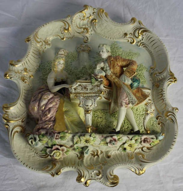 Vintage Italian Court Scene Wall Plaque: Length 22 Inches Width 19 Inches Depth 2 Inches. Depicting a man and woman at a piano. Property of a Mamaroneck NY Estate.