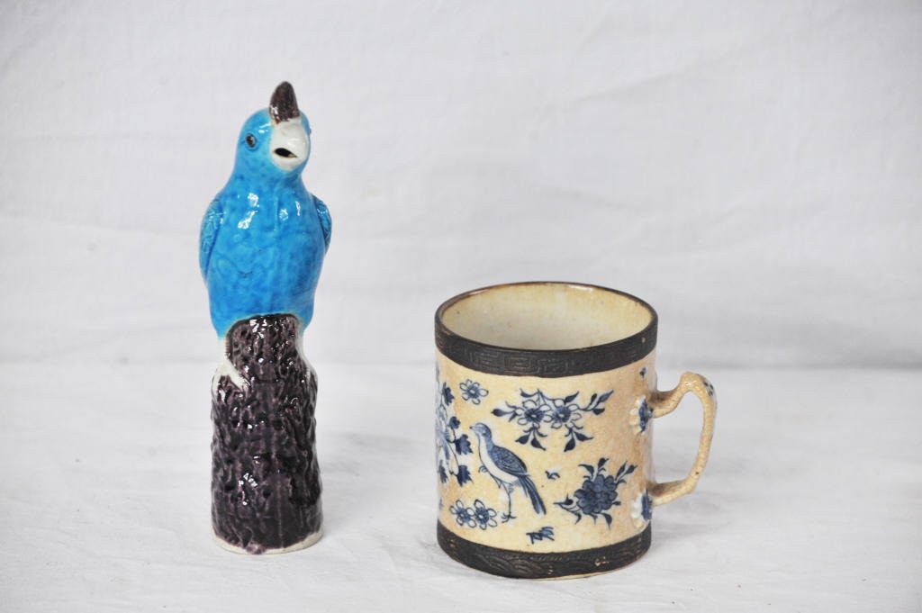 Two Antique Asian Articles: One mug, stamped on bottom, and one blue and purple porcelain bird. Mug Height 4.5 Inches Width 5 Inches Diameter 4 Inches Bird Height 9 Inches Width 2 Inches Depth 3 Inches