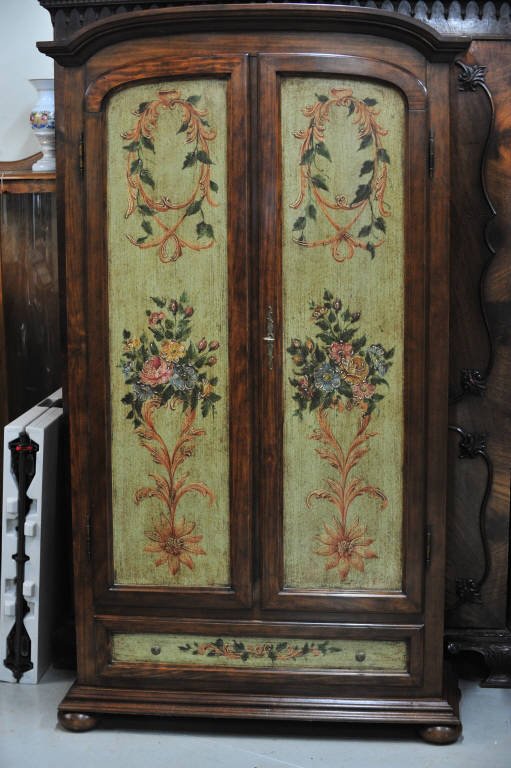 Floral Painted Armoire by Decorated Craft Inc.: Two doors, one bottom drawer. Painted with decorative floral motif on doors and along sides. Height 74 Inches Width 38 Inches Depth 13 Inches