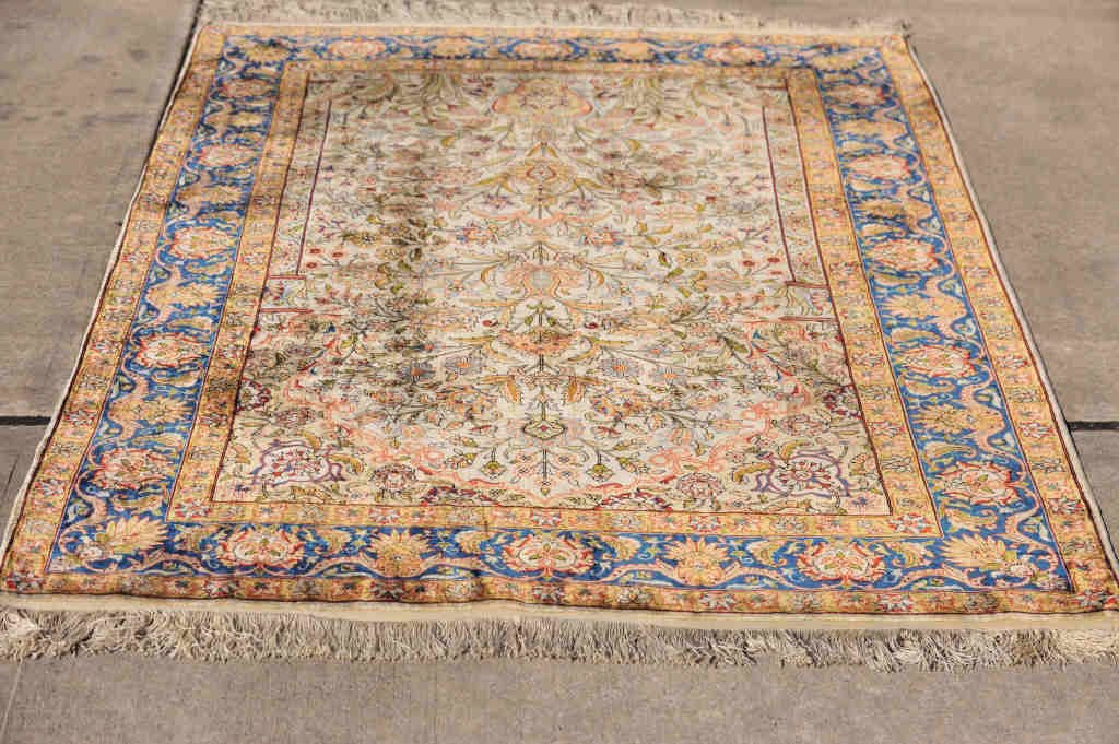 Hereke Silk Rug: Blue border with plant motif in olive green, orange, blue, and pink. 70 Inches by 48 Inches