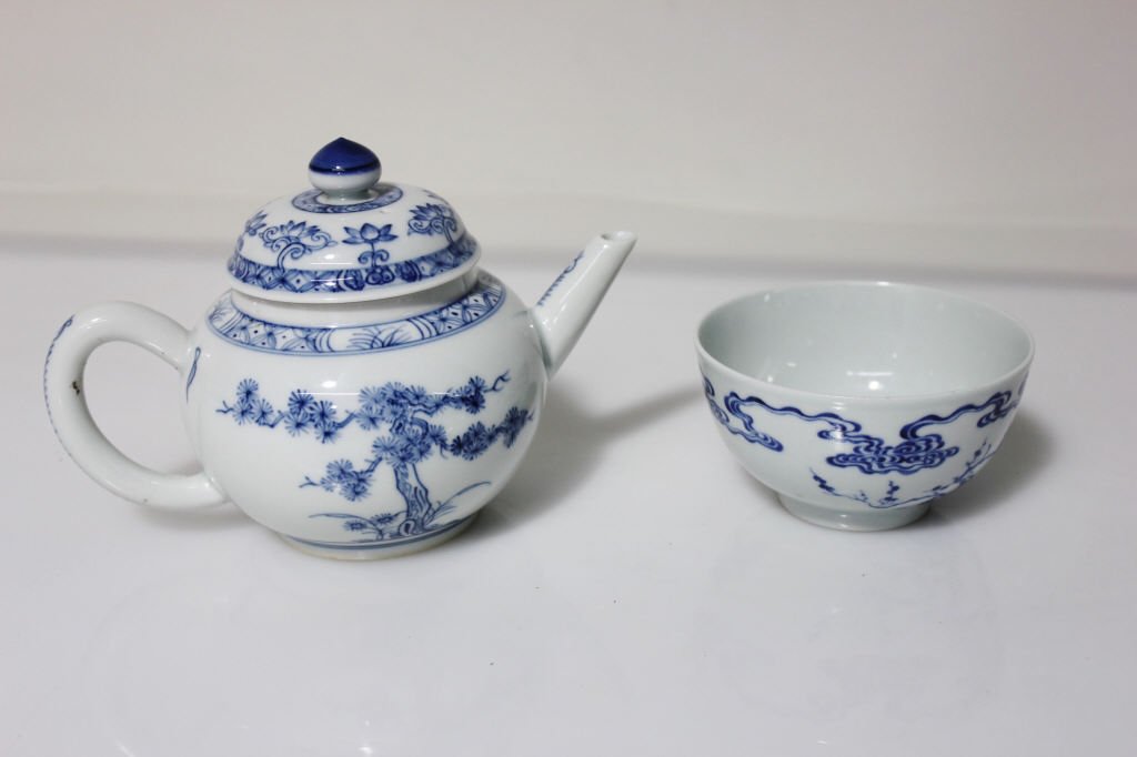 Blue and White Tea Bowl and Tea Pot: Pot height: 5 inches. Diameter: 6 inches. Cup height: 2 inches. Diameter: 3.75 inches.