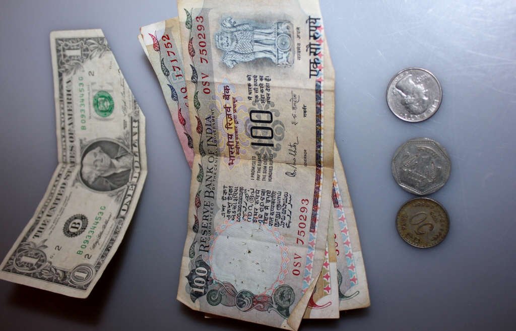 US and Bank of India Currency: One US $1 dollar bill, three Bank of India $100 notes, one US quarter dollar and two foreign coins.