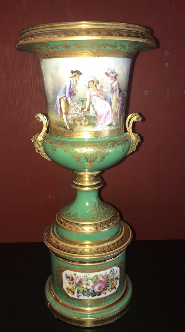 19th Century Sevres Porcelain Vase.: Decorated hand-painted scenes with stylized gold overlay on a pale mint-green field. The obverse panel depicts a flower garden with ladies and gent dressed in formal attire. The reverse with a young l