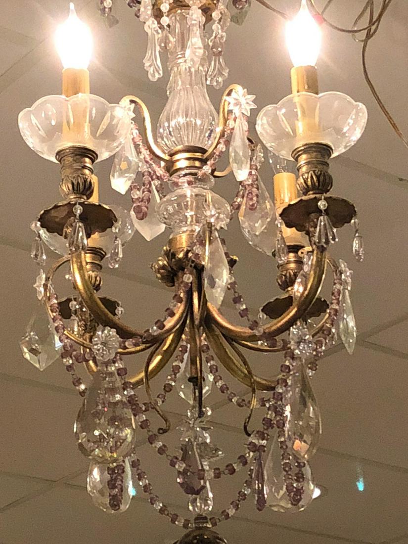 Parisian Crystal & Bronze Chandelier.: Having u-shaped arms ending in scalloped candle cups and accented with amethyst-tinted crystals. Possessing large almond and kite shaped prisms, small rosettes, and cascading beads. 29H x 14W. 99-736