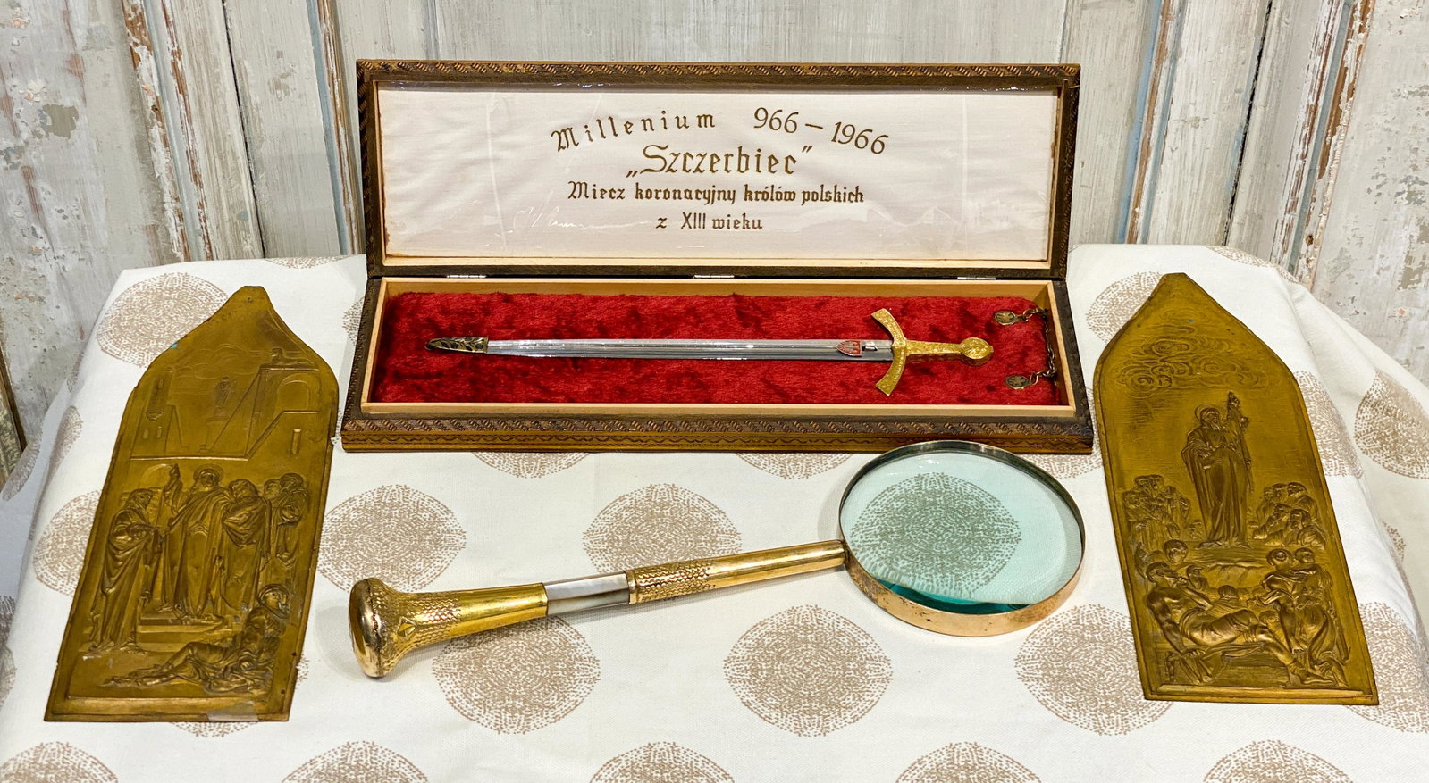 4 Piece Lot Including Miniature Sword: Commemorative Coronation sword king of Poland, 1966, together with mother of pearl magnifying glass and pair of brass embossed religious panels. Magnifying glass 12 long