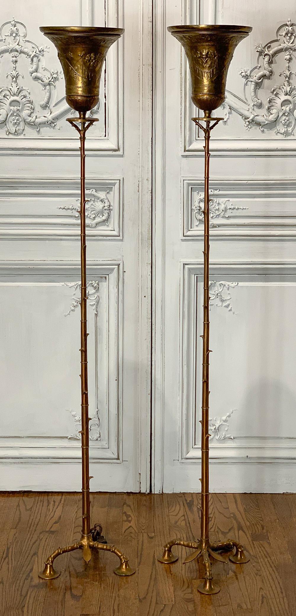 Embossed Brass Torchieres From The Bass Estate: With 19th Century Detailed Embossed Brass Shades On Later Bases. Each 67.5h X 12.5w. Electrified And In Working Condition. Owner Repute Ex-bass Estate.
