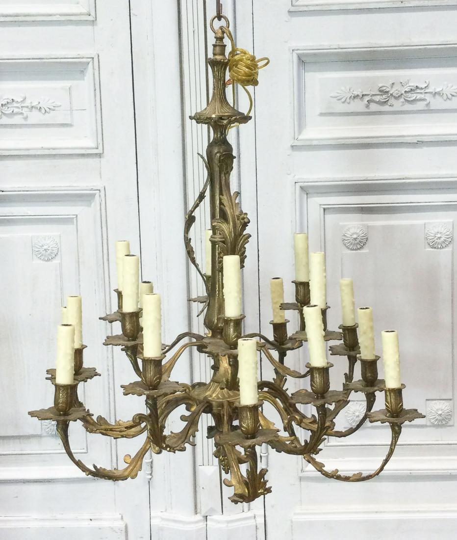 Louis XV Style Gilt Bronze Chandelier: 20th Century, Waisted Corona And Foliate Appliques, Urn Circlet Issuing Eighteen Acanthus Candle Arms, Grape Pendant, Electrification Present, But Not Guaranteed. Attractive Patinated Surface Througho