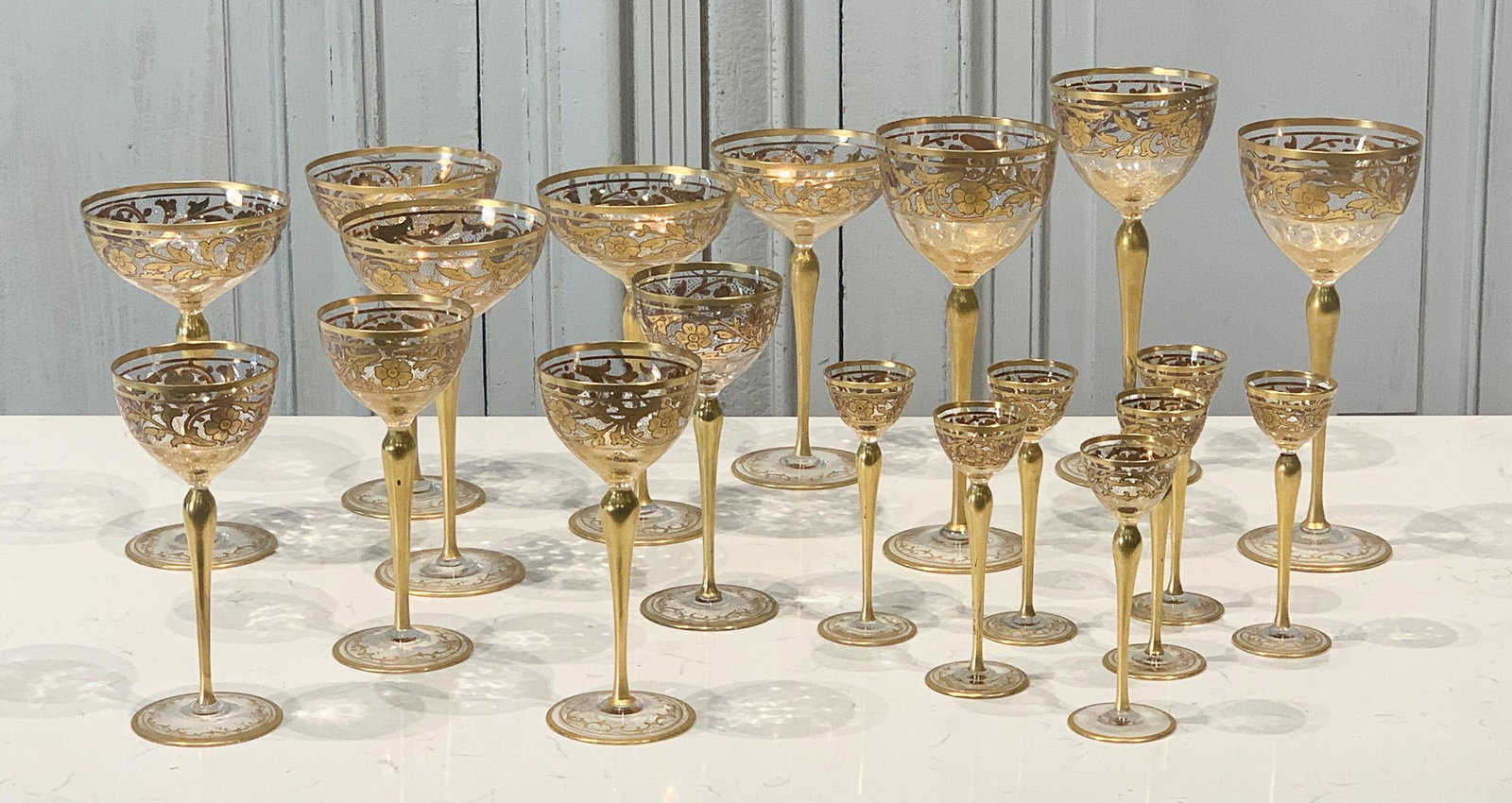 19 Venetian Gilt Glass Wine Stems: Italian, 20th Century, Five Large Champagne Coups, Three Red Wine Glasses, Four White Wine Glasses, And Seven Aperitifs, Red Wine Height 9 Inches, Variation To Gilding On Aperitifs, Metal Sheath Repai