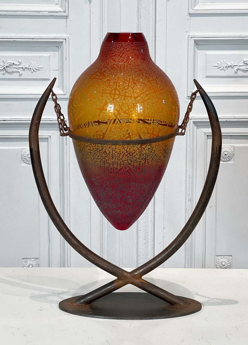 Large Duncan McClellan Studio Glass Vase: American, Late 20th Century, Orange Glass Vessel Etched With Alchemy Symbols On Wrought Iron Stand, Signed Near Upper Edge, Overall Height 29, Width 19, Depth 12 Inches, Base Unevenly Oxidized. See Ph