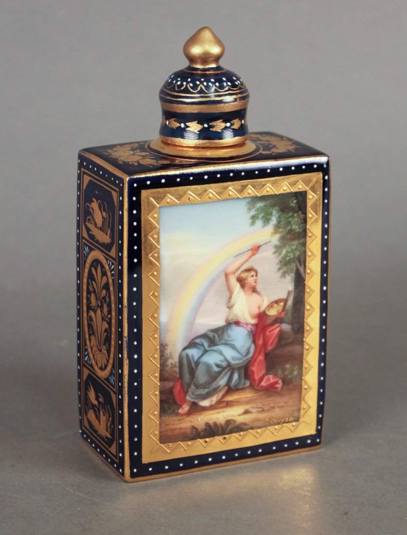 Royal Vienna Capped Perfume Bottle: with painted scene of cherubs playing musical instruments and classical lady under rainbow on reverse, gold overlay side and top highlights. 6.6" high, 3.25" wide x 2" deep. Marked with Blue beehive m