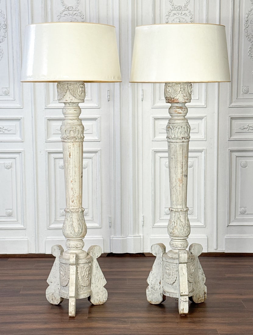 Pair Neoclassical Style Carved Wood Torcheres: Pair Neoclassical Style Carved Wood Torcheres As Lamps, Italian, Tall Antique White Painted Columns With Cherub Angel Masques, Parchment Shades, Later Electrification And Tripod Buttress Supports, Ove