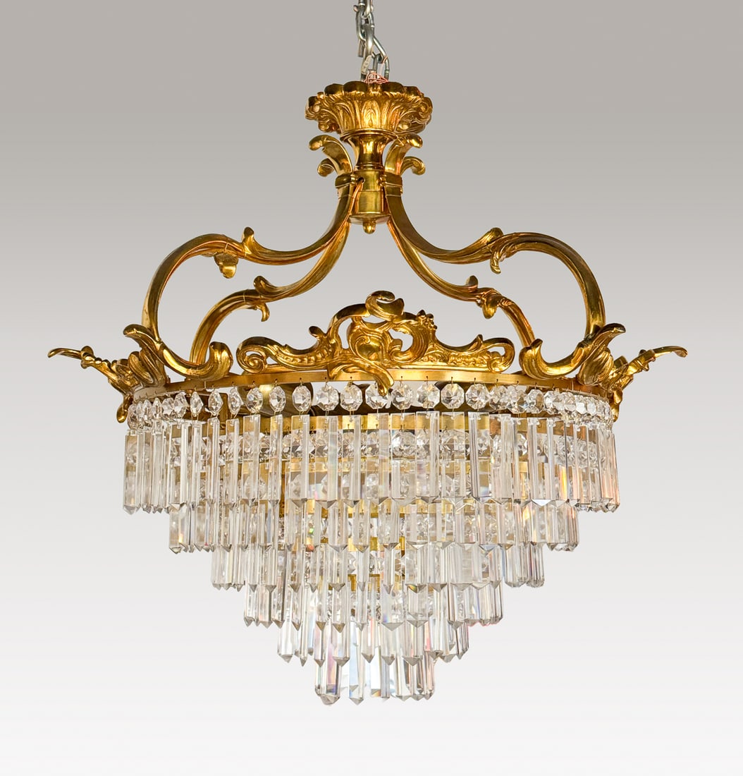Baccarat Style Gilt Bronze Chandelier: Italian Or French Baccarat Style Gilt Bronze & Cut Glass Chandelier, Foliate Circlet Issuing Graduated Tiers Of Triangular Crystals, Height 24 Inches, Width 26 Inches, From The Collection Of Thomas Gr