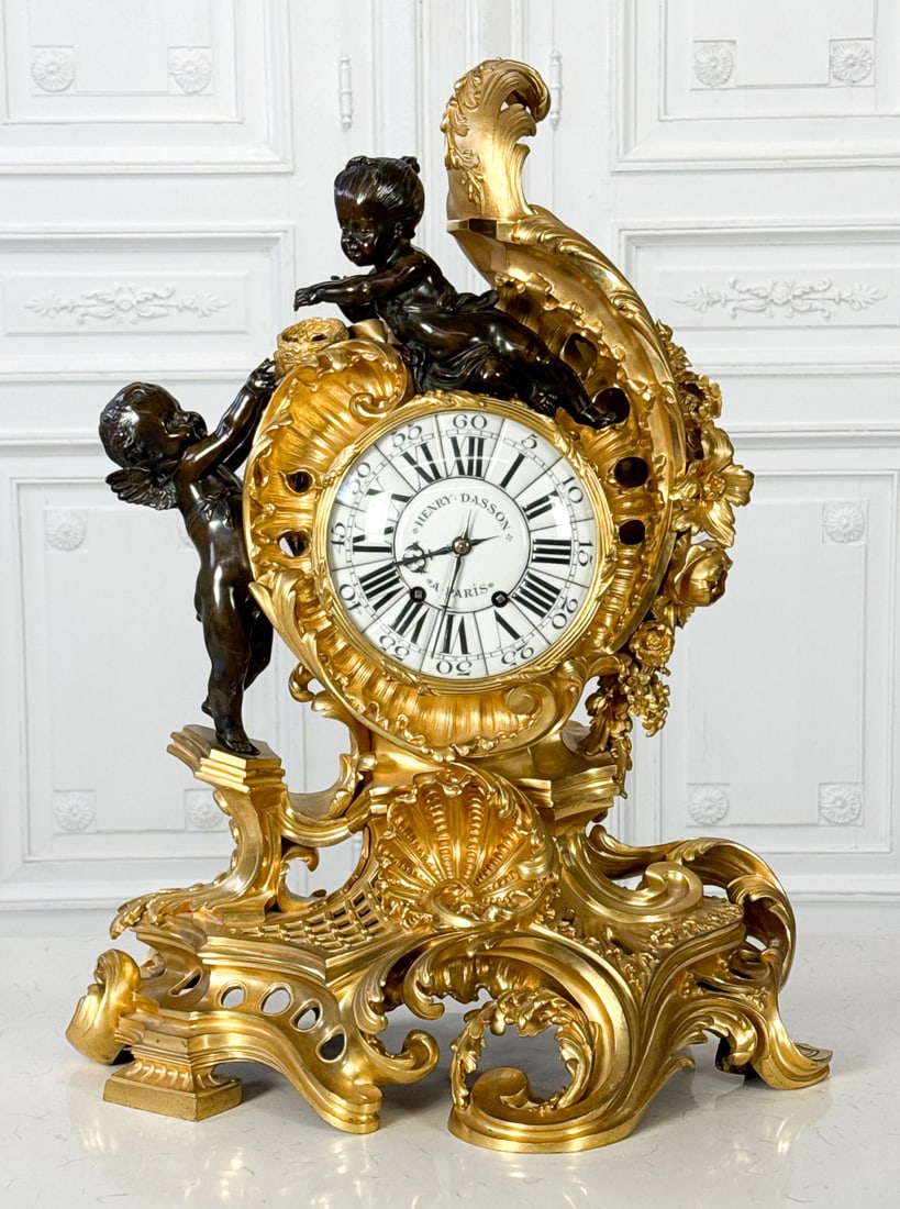 Large Henry Dasson Parcel Gilt Bronze Clock: Large Henry Dasson Parcel Gilt Bronze Clock, French, Late 19th Century, In The Rococo Taste, With Exuberant Rocaille Case With Infant Cupid And Psyche With A Bird's Nest, Enamel Dial Marked Henry
